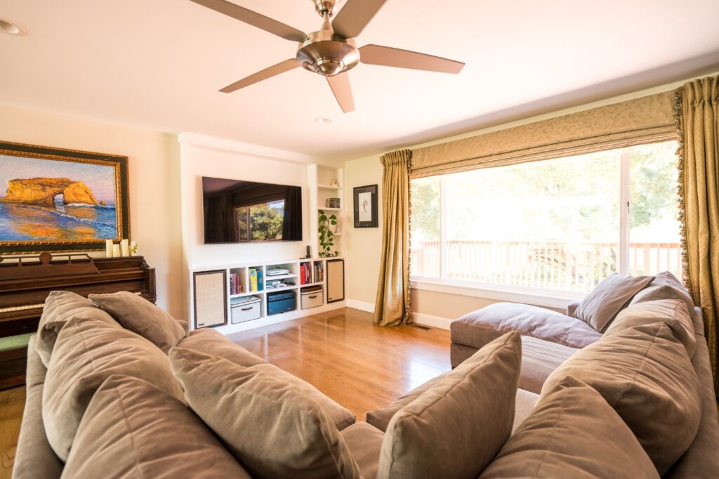 Wide shot of living room sofa and entertainment options with garden view at Vineyard Chateau