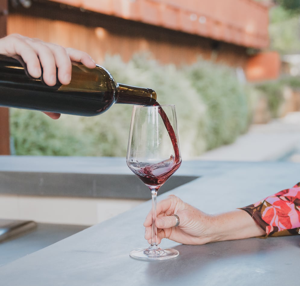 VINCENT VINES Estate Merlot being poured into a glass at the poolside bar, Vineyard Chateau