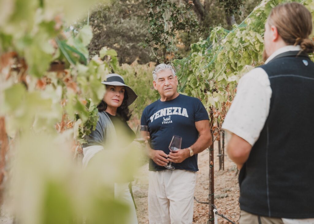 Couple enjoying a hosted wine experience in the VINCENT VINES Estate Merlot vineyard at Vineyard Chateau